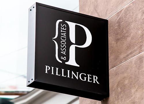 a black and white sign for Dillinger & associates on the side of a building .