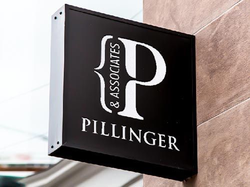 a black sign on the side of a building that says pillinger & associates.