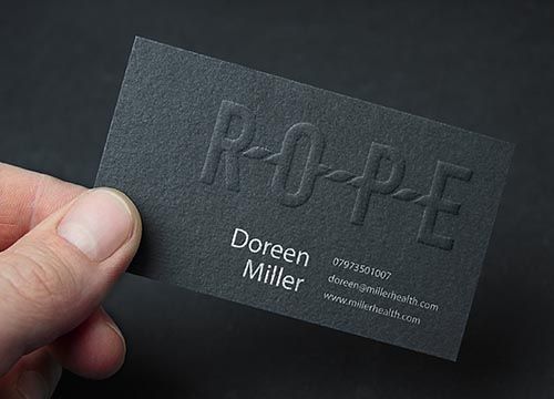 a person is holding a black business card in their hand .