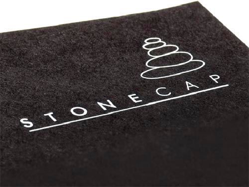 a close up of a piece of black textured paper with a white logo on it.
