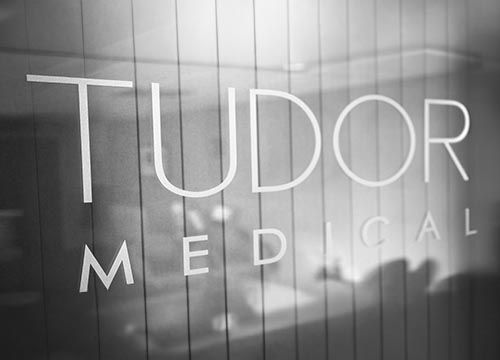 a black and white photo of a tudor medical vinyl window sign