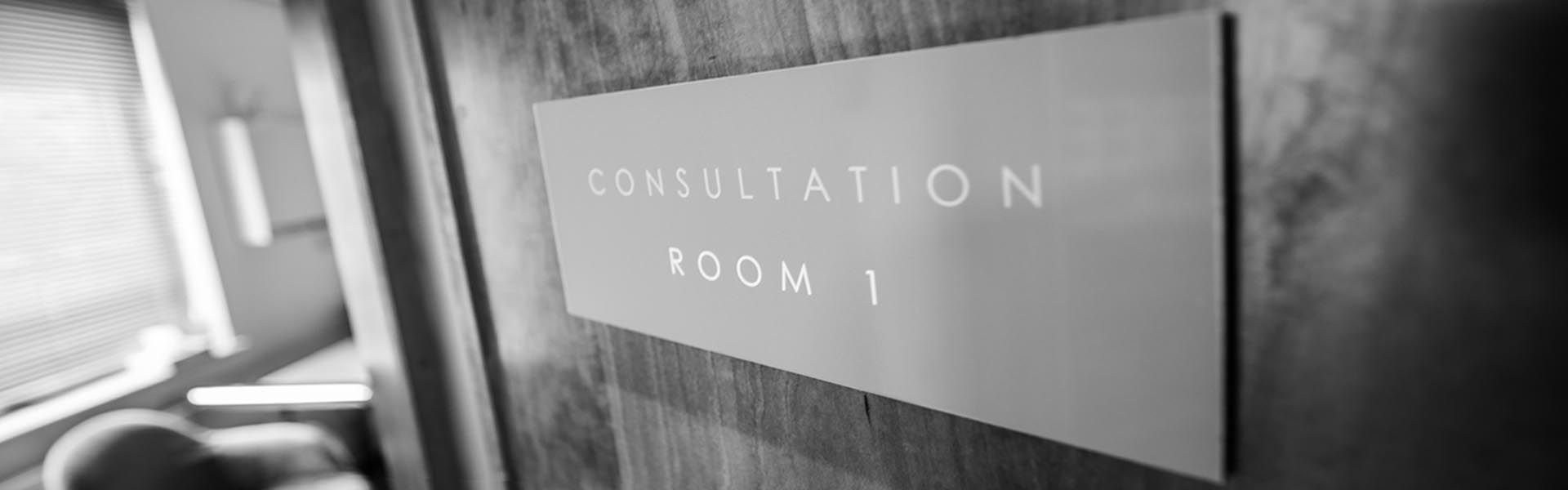 a sign that says consultation room 1 on it
