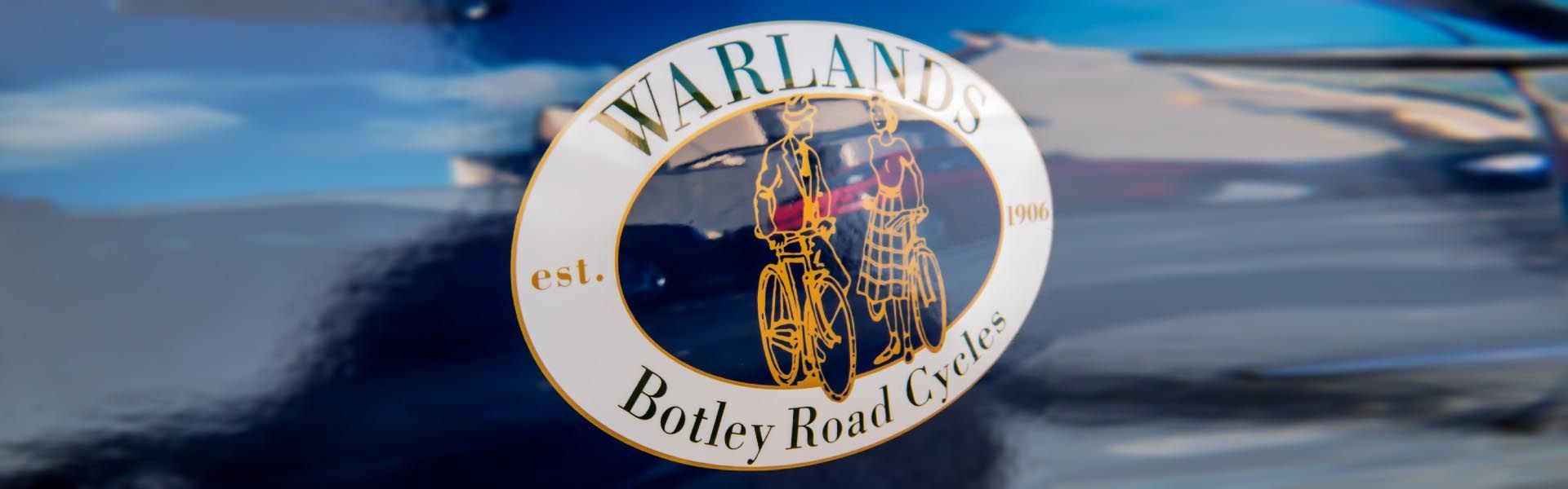 a vinyl vehicle logo on the side of a car that says warlands botley road cycles