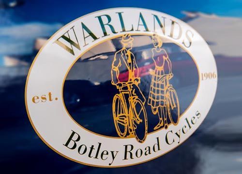 the logo for warlands botley road cycles is on a car door .