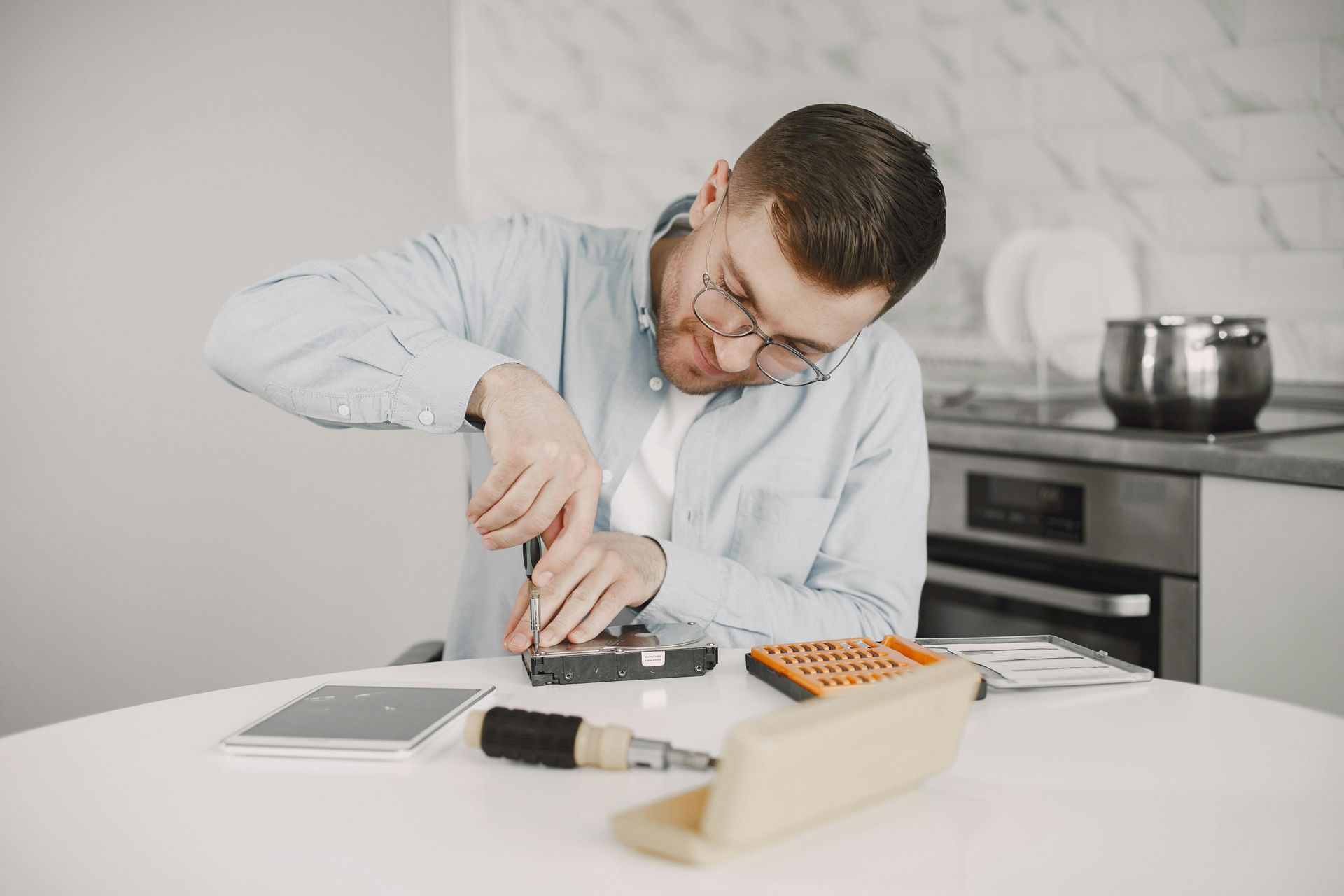 Man repairing electronic appliance in kitchen – washer appliance repair and diagnostic service near you.