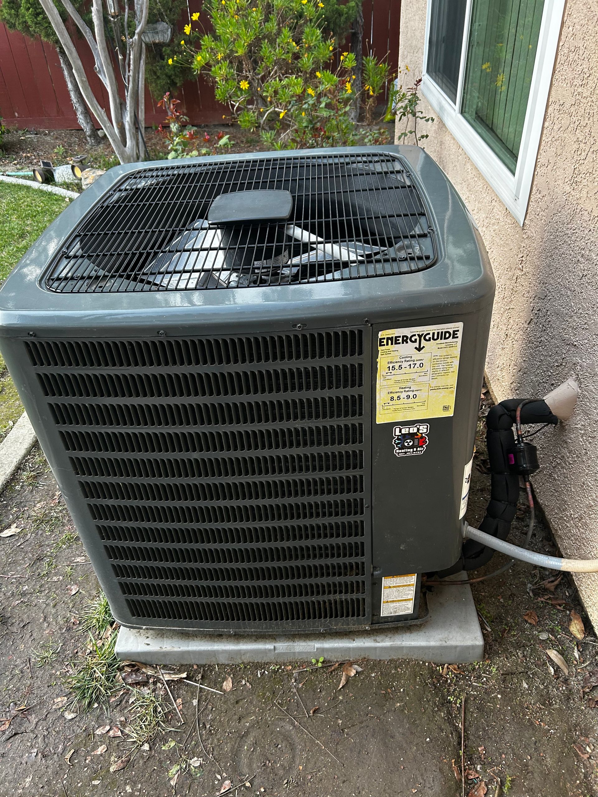 A large air conditioner is mounted on the side of a building.