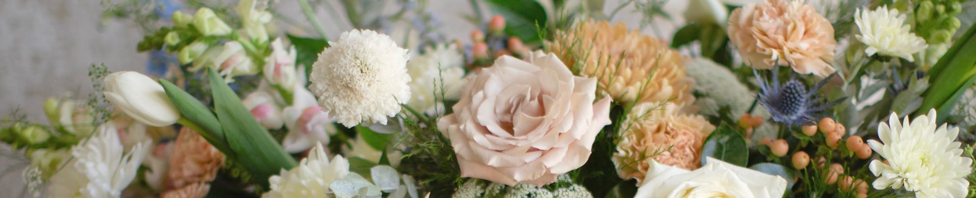 Close-up of a colorful flower bouquet with white, pink, peach, and purple blooms.