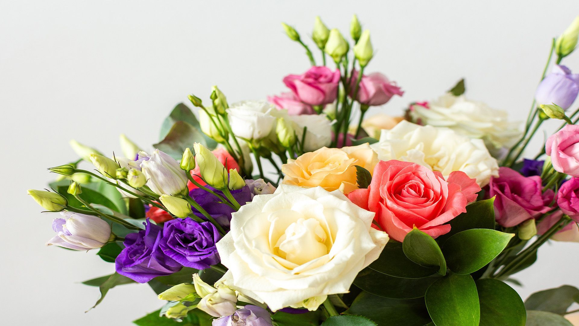 Close-up of a colorful flower bouquet with white, pink, peach, and purple blooms.