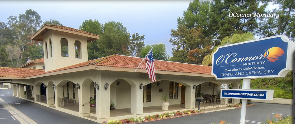 Building with an American flag, terracotta roof, and arched openings.