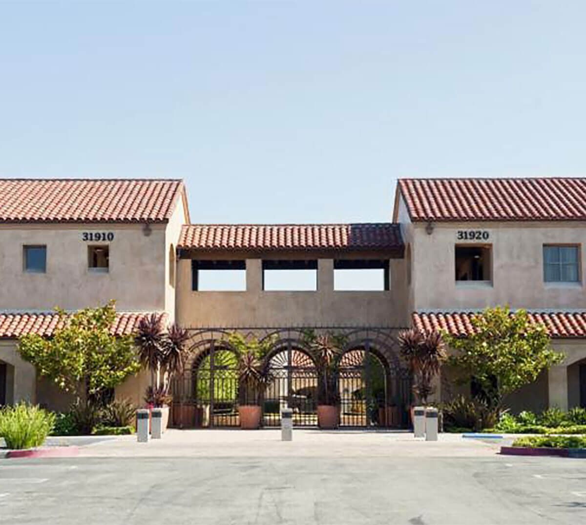 Spanish-style building with terracotta roof, arched entrance, and street address 31610 and 31620.