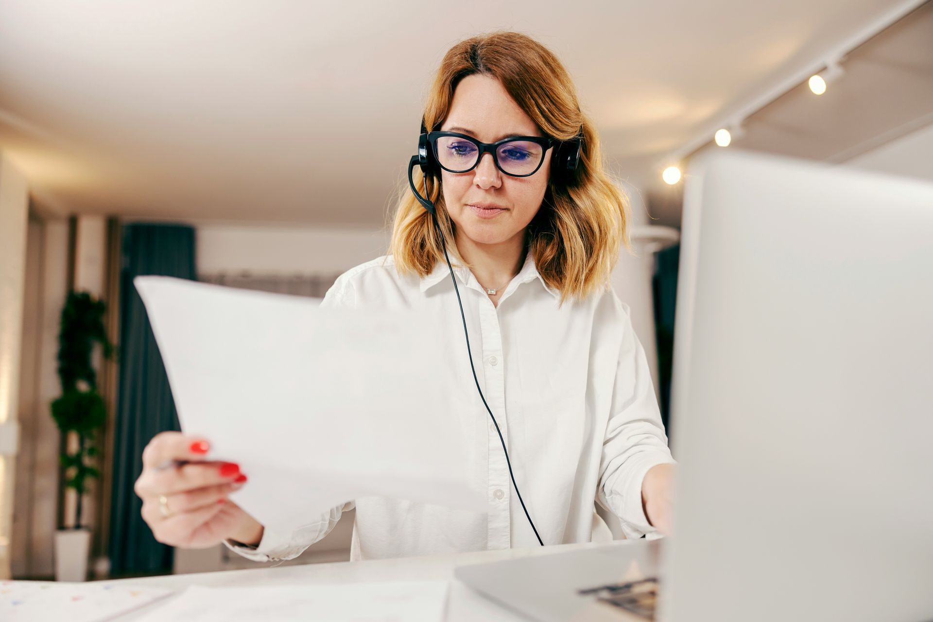 Hands pointing at documents, discussing, with a phone on the table.