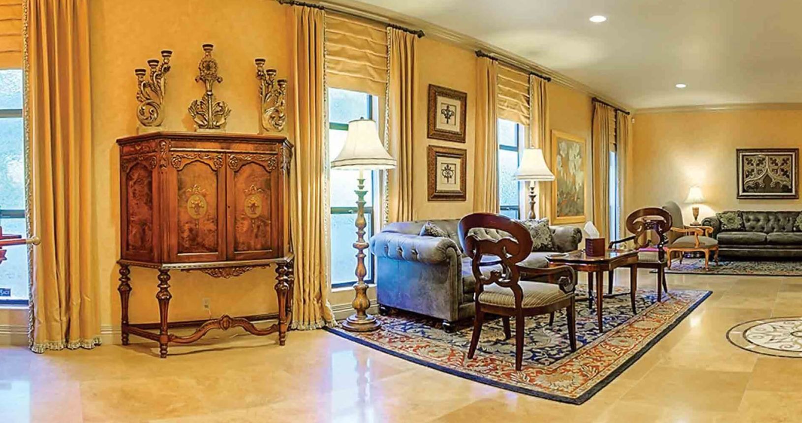 Living room with tan walls, furniture, and large windows.