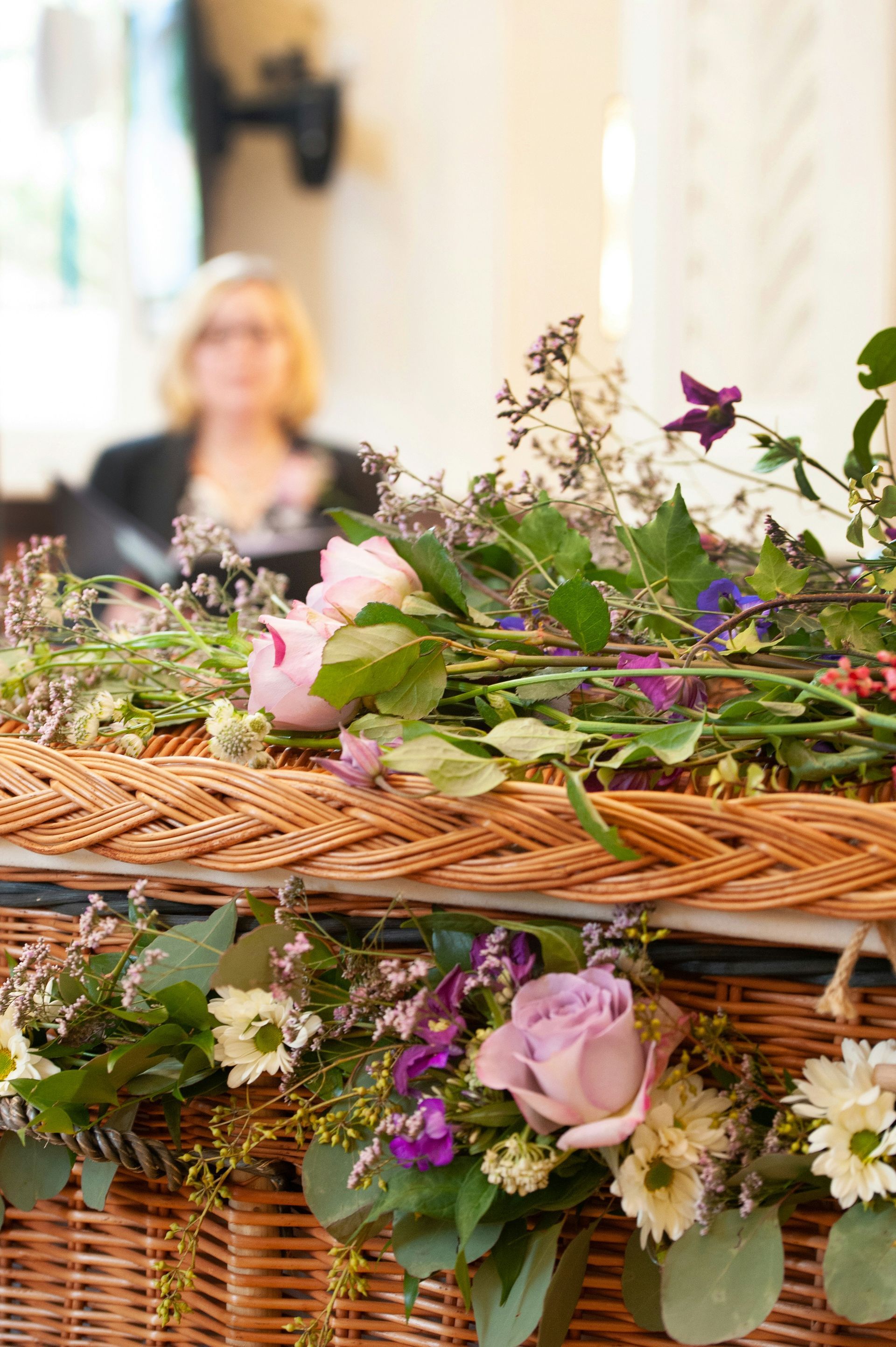 Copper urn with floral arrangement, surrounded by lit candles in a ceremony setting.