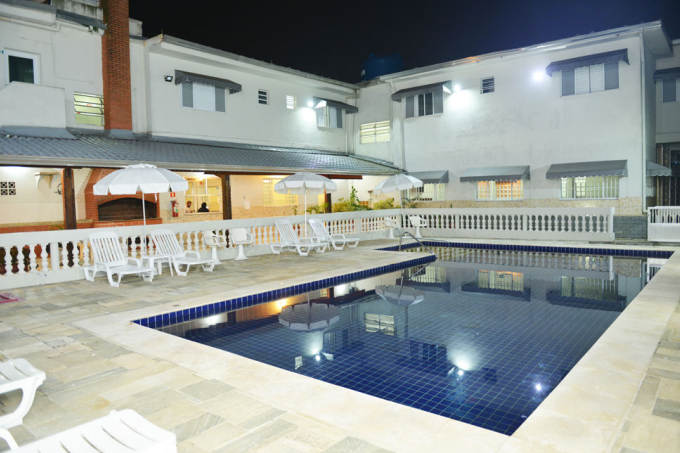 Uma grande piscina em frente a um prédio à noite