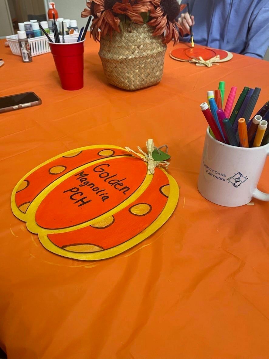 A table with a sign in the shape of a pumpkin on it.