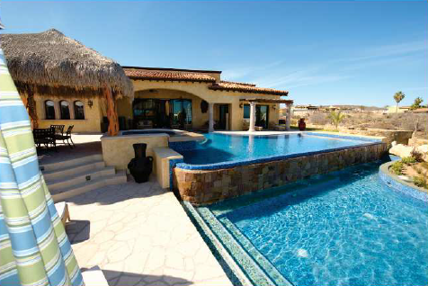 A large house with a swimming pool in front of it