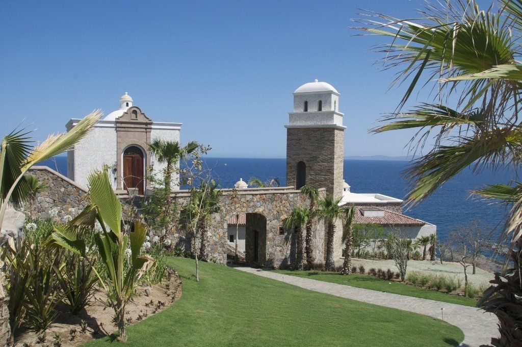 A large stone building with a tower on top of it overlooking the ocean