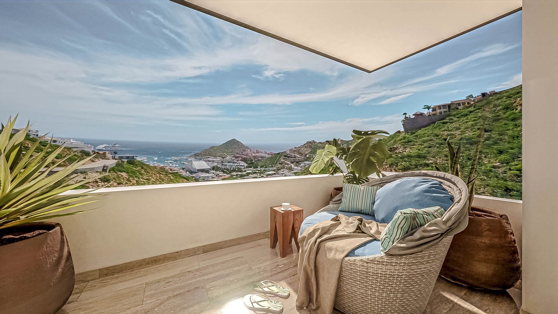 A balcony with a chair and a view of the ocean.