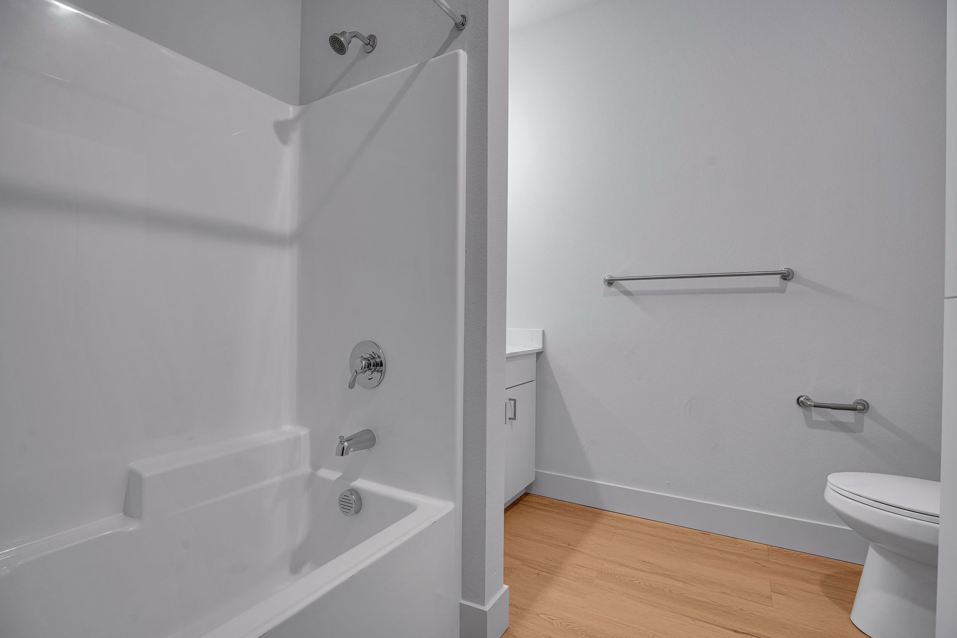 A bathroom with a bathtub , toilet and shower.