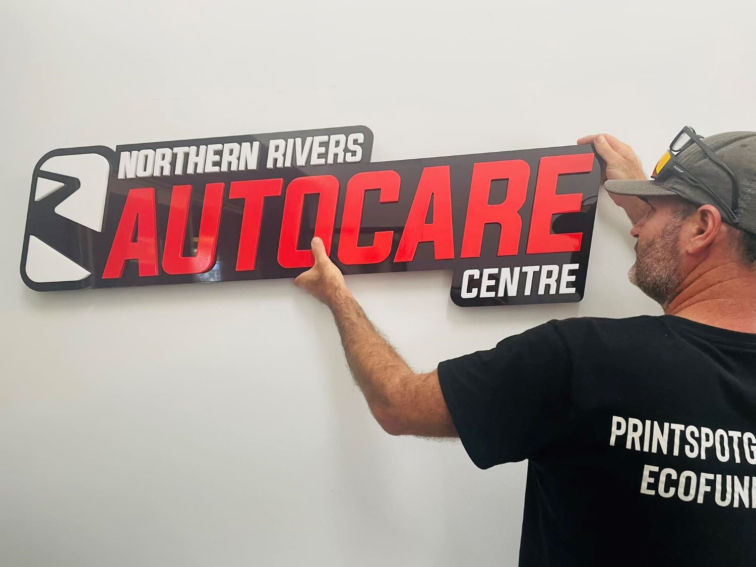 A Man is Holding a Sign — Print Spot Group in Tweed Heads, NSW