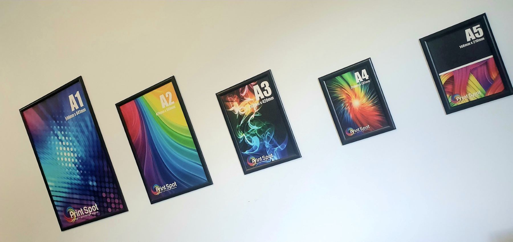 A Row of Colorful Posters Are Hanging on a Wall — Print Spot Group in Coolangatta, NSW