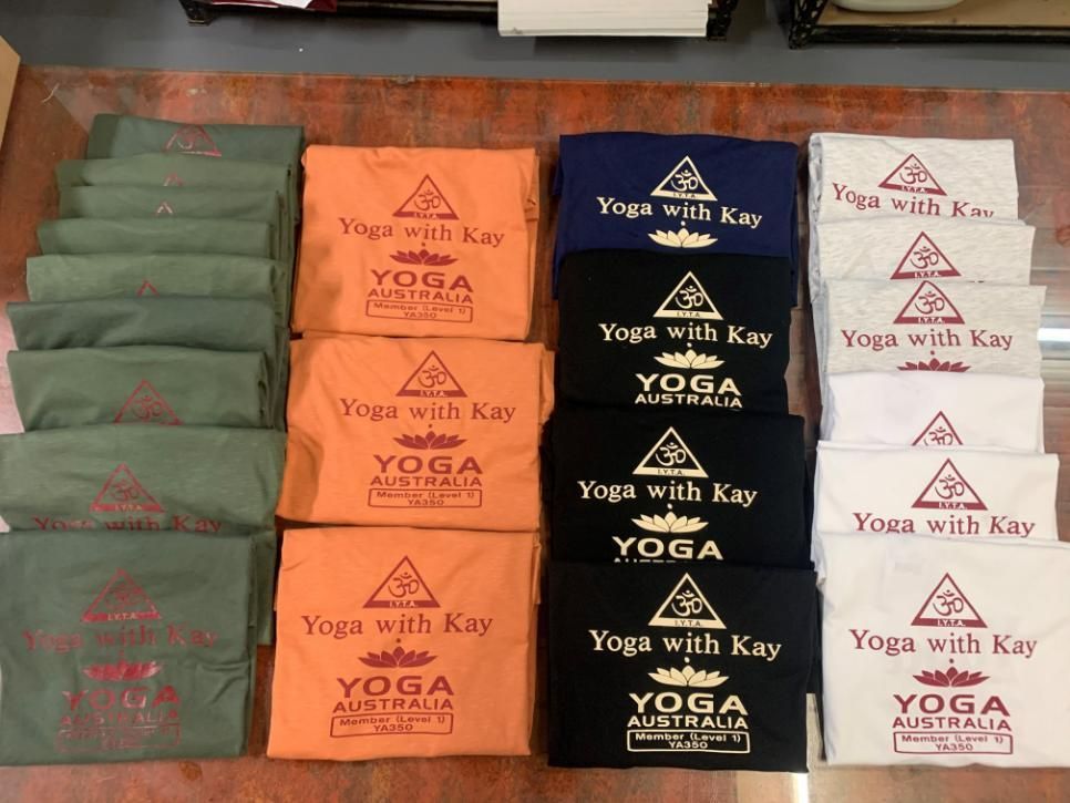 A Bunch Of Yoga With Kay T-Shirts Are Stacked On Top Of Each Other — Print Spot Group In Tweed Heads, NSW