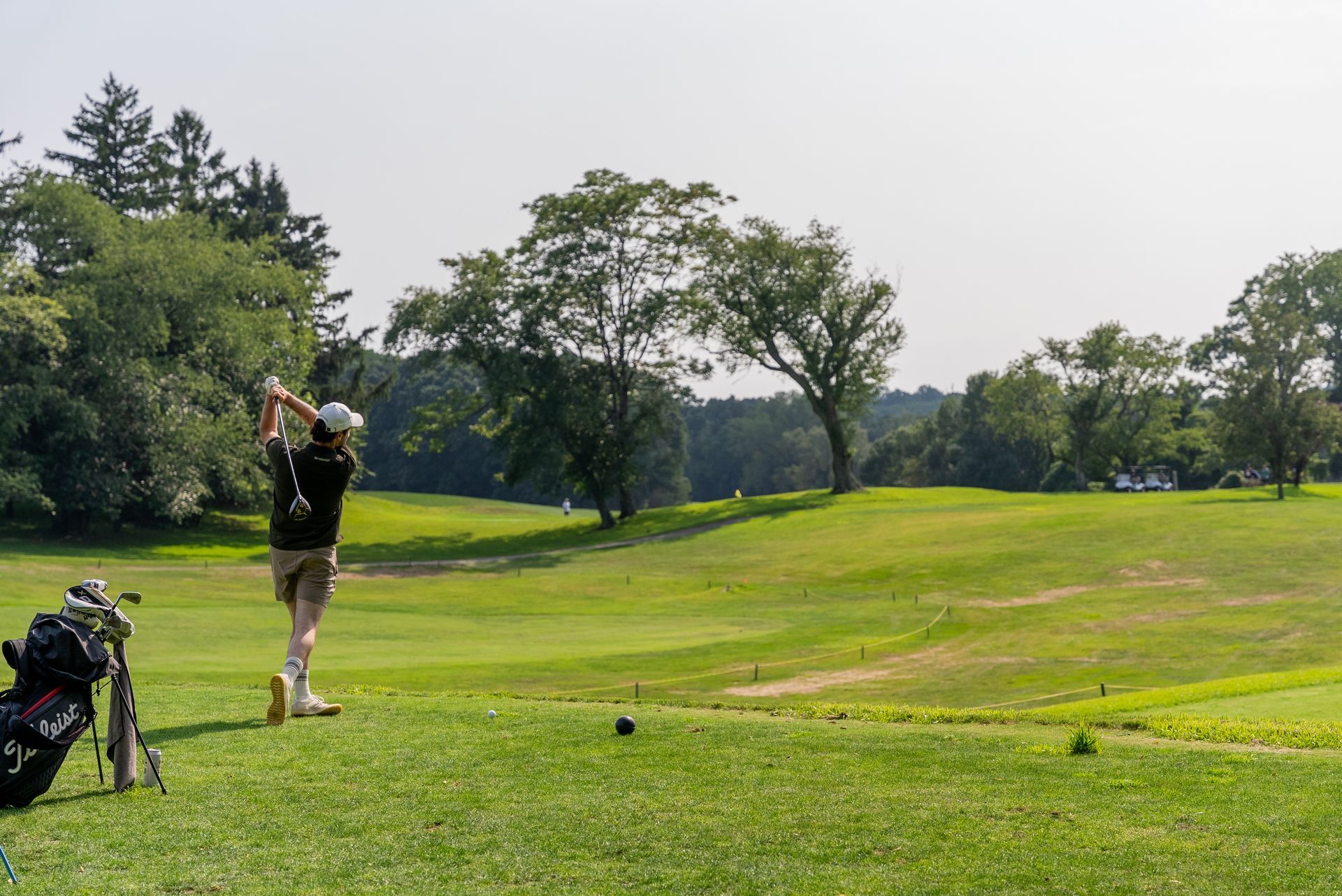 A man is swinging a golf club on a golf course.