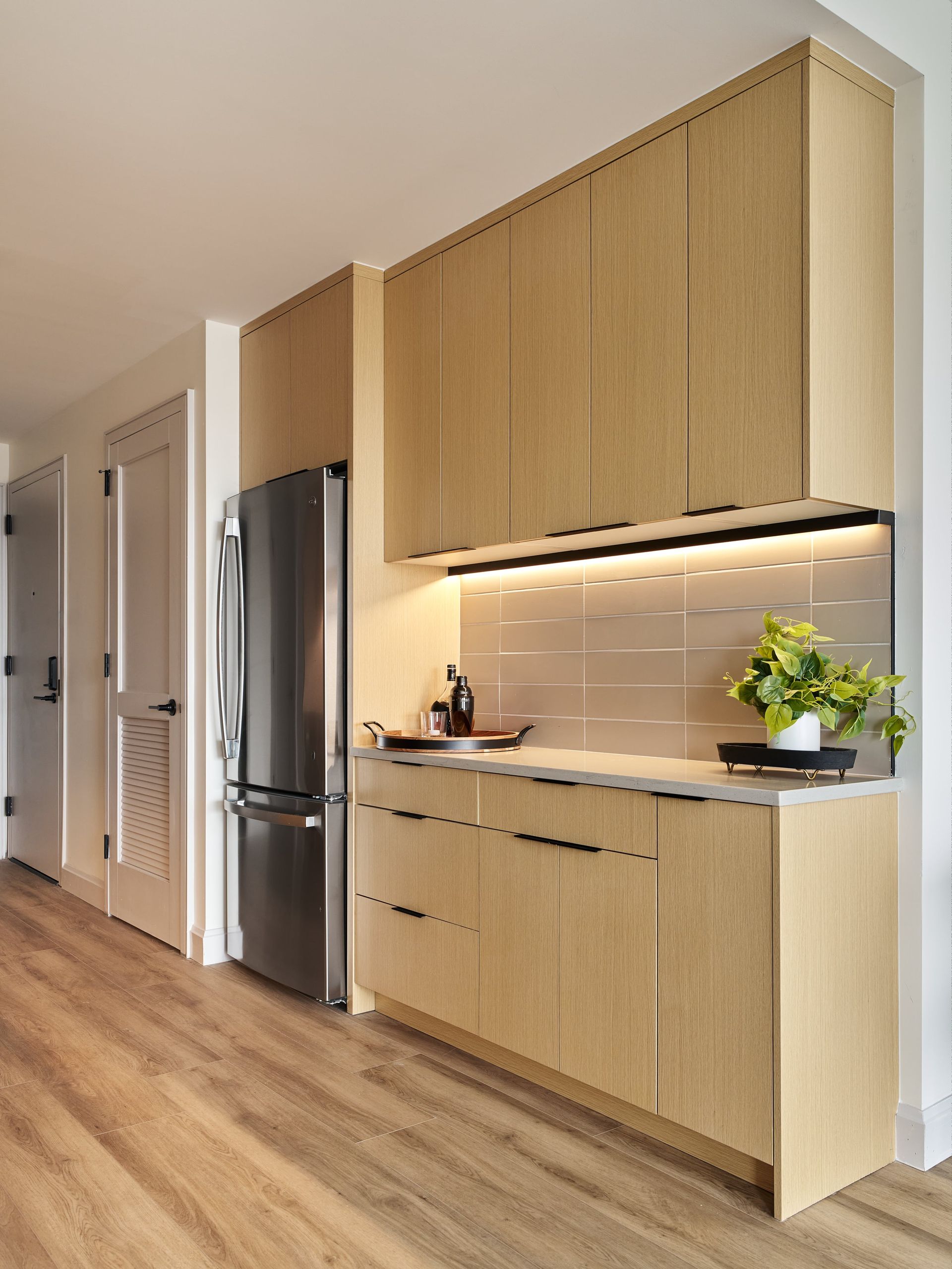 A kitchen with wooden cabinets and a stainless steel refrigerator
