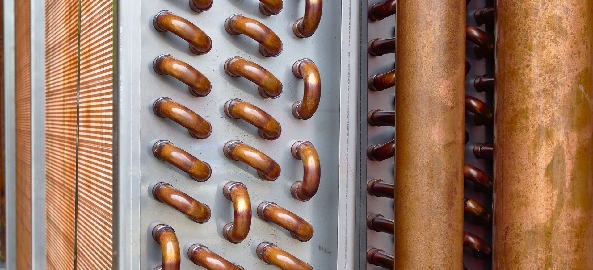 Close up shot of copper plain tubes of a condenser coil - commercial hvac coil cleaning