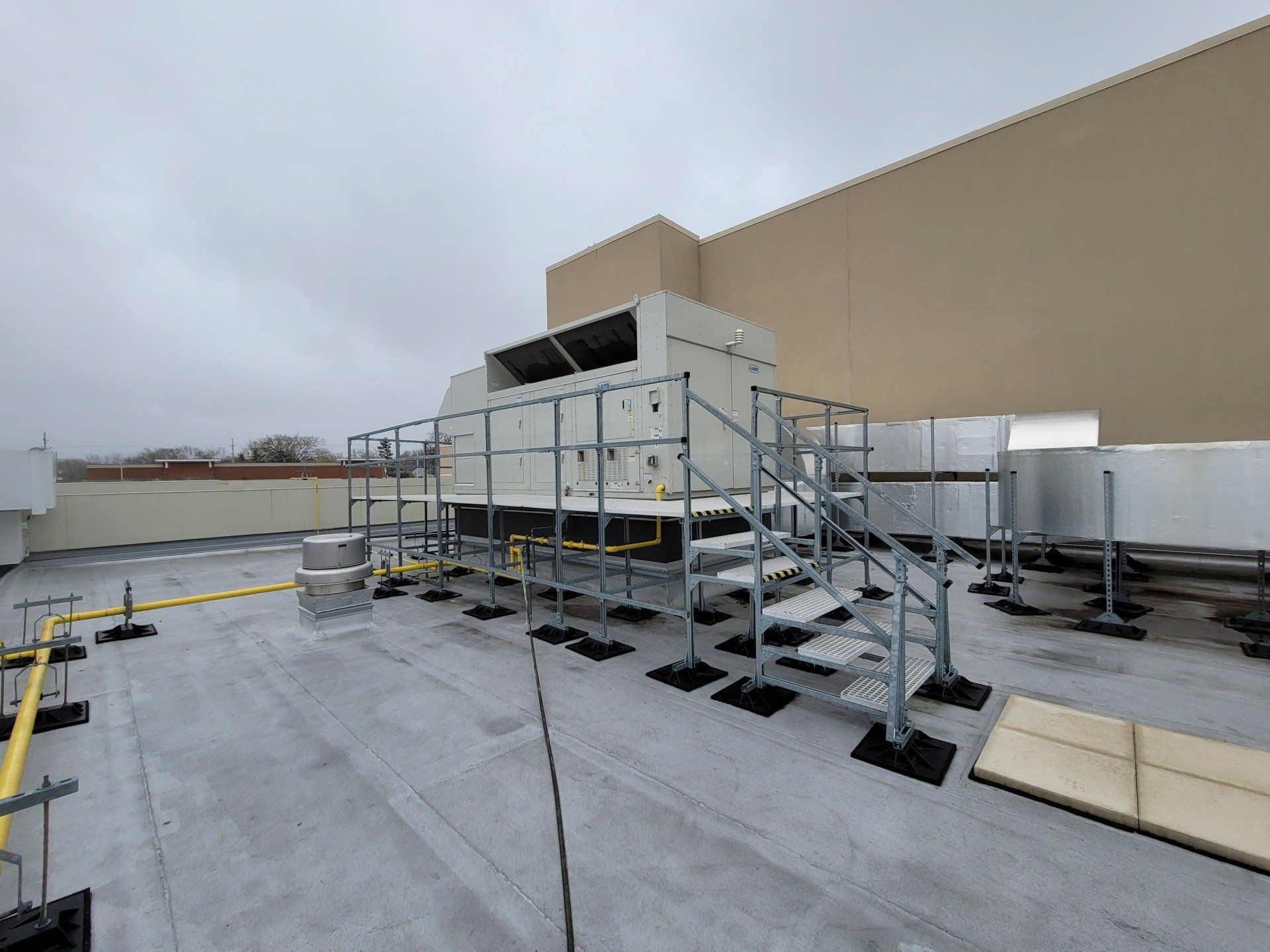 A large air conditioner is sitting on top of a roof.