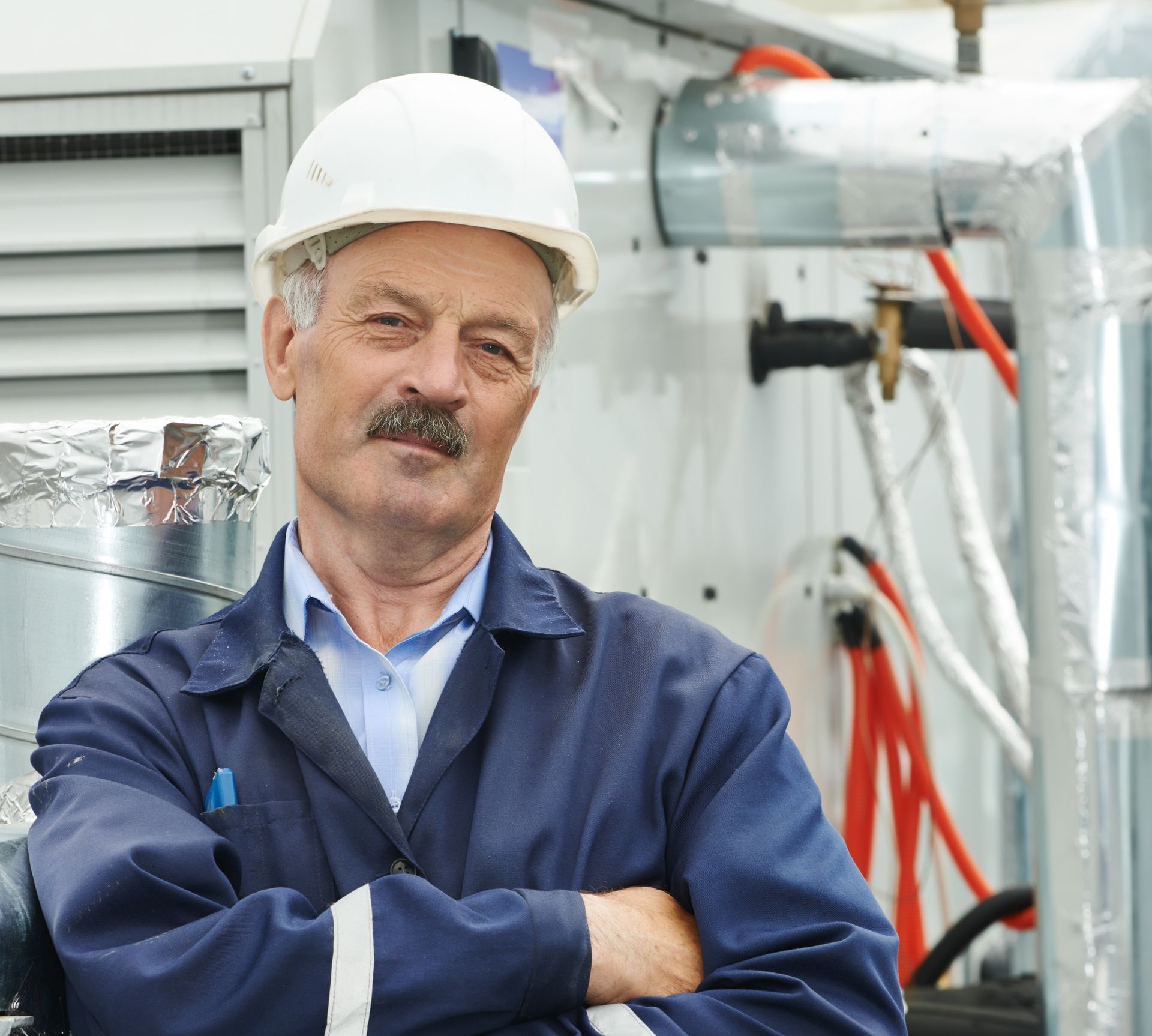 the technition poses for a head-on portrait, he smiles knowing the asnwer to the question how long do commercial HVAC systems last