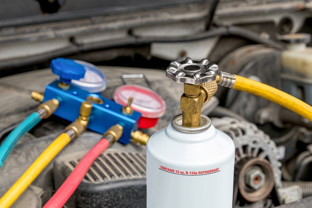 A bottle of gas is sitting on top of a car engine.