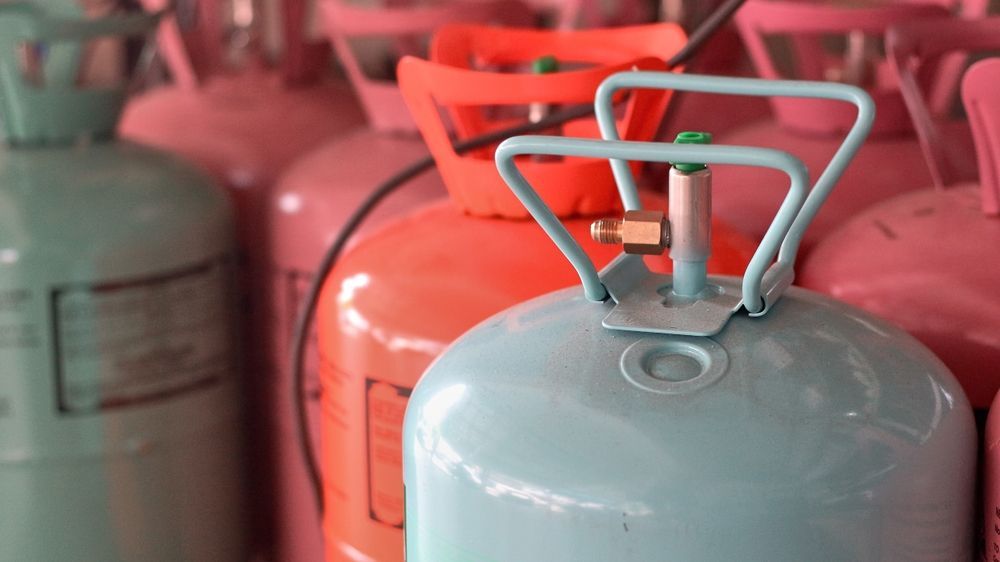 A bunch of gas cylinders are lined up in a row.