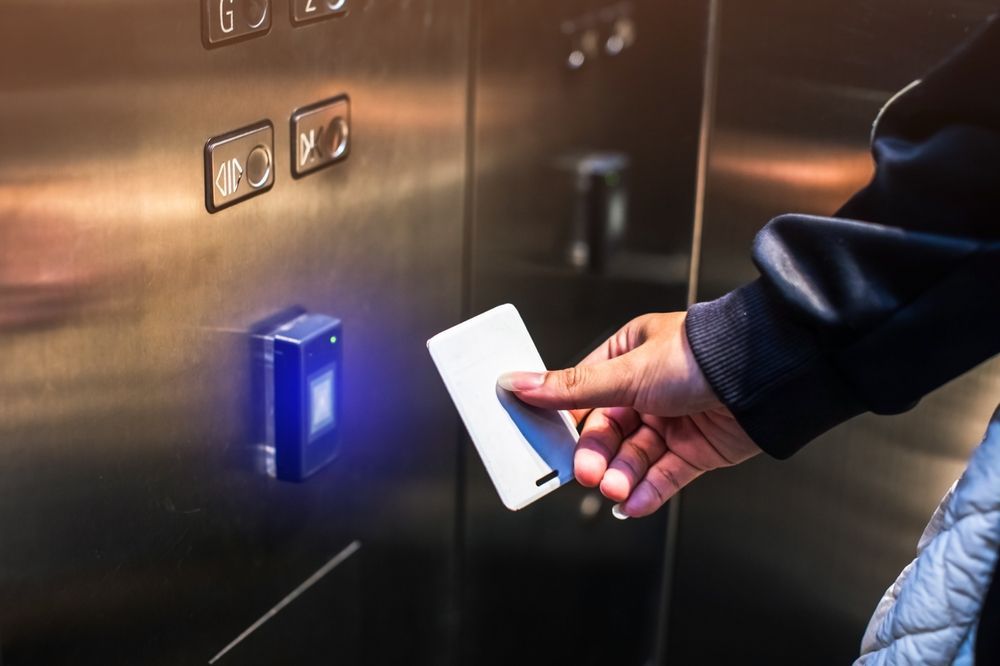 A person is using a smart card to enter an elevator.