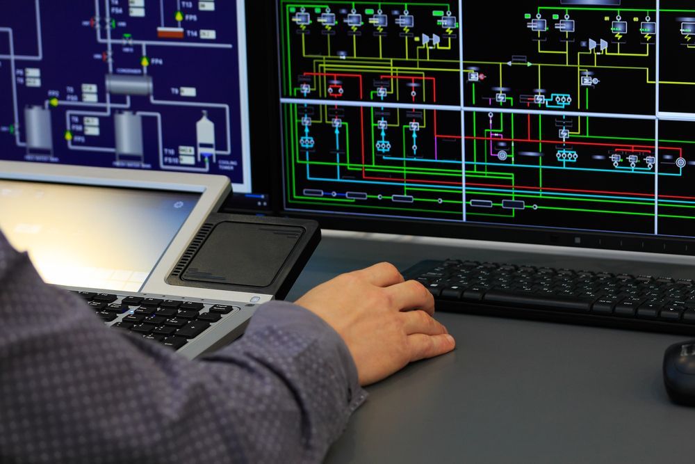 A person is typing on a keyboard in front of a computer screen