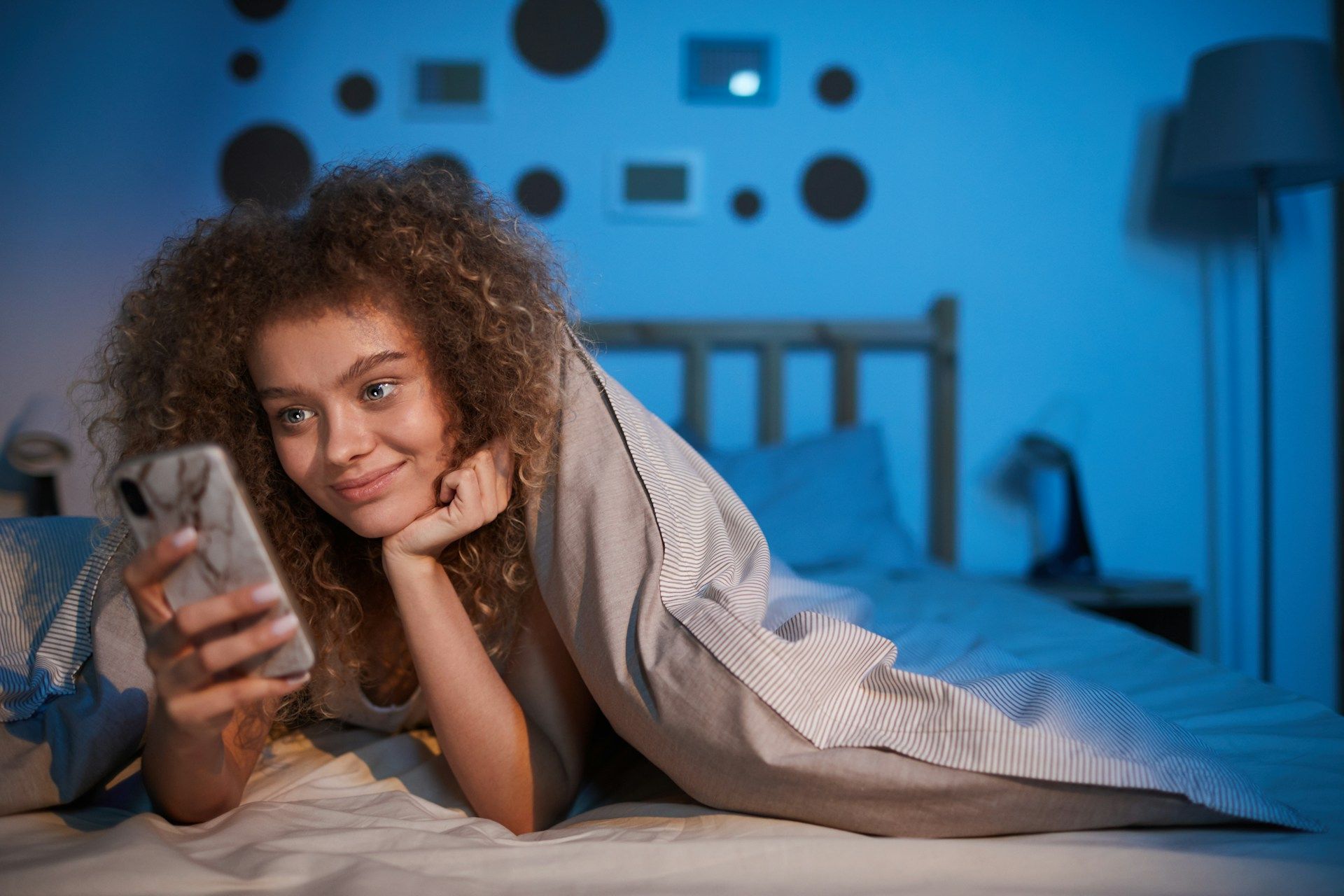 woman using smartphone in bed