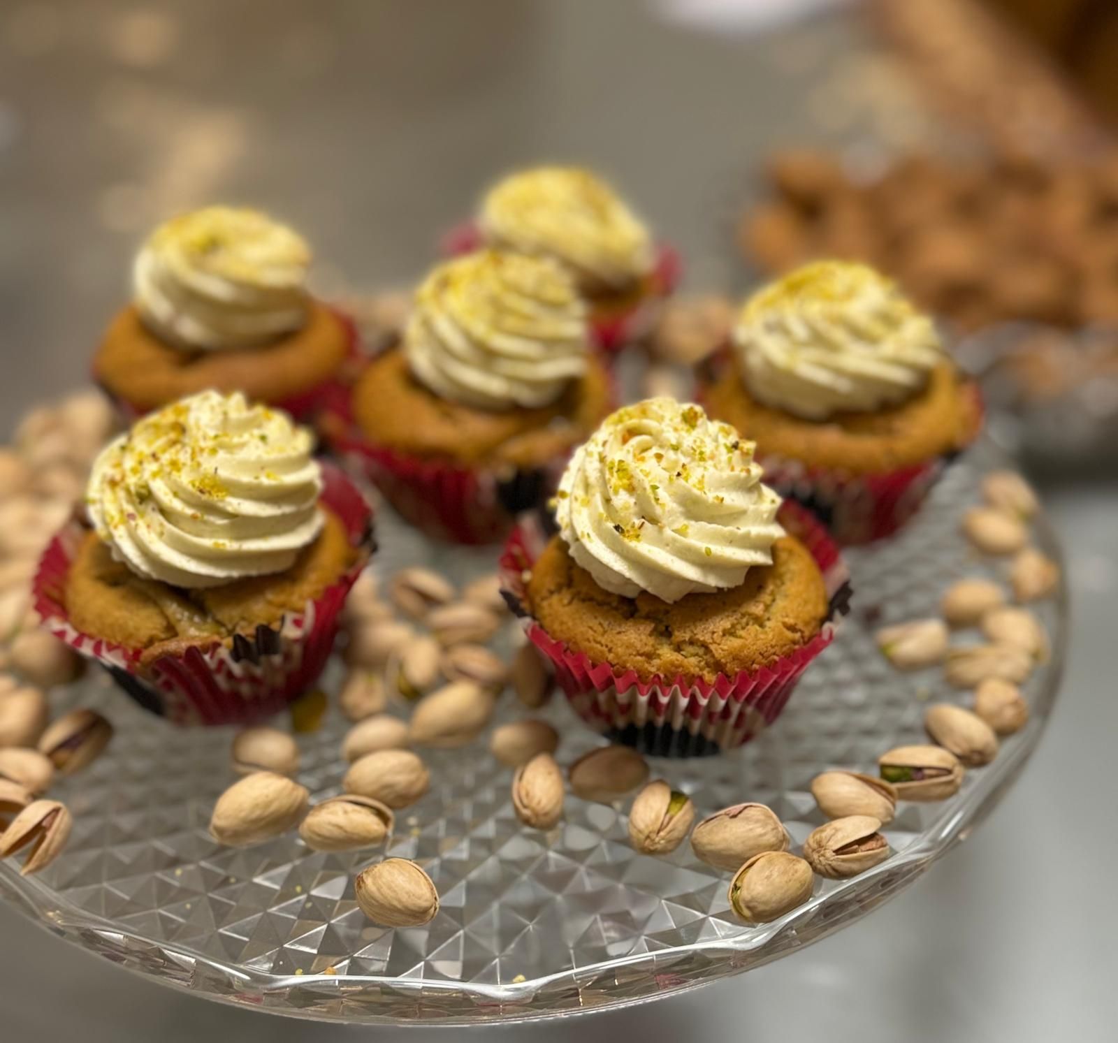 un plateau en verre rempli de cupcakes et de pistaches .