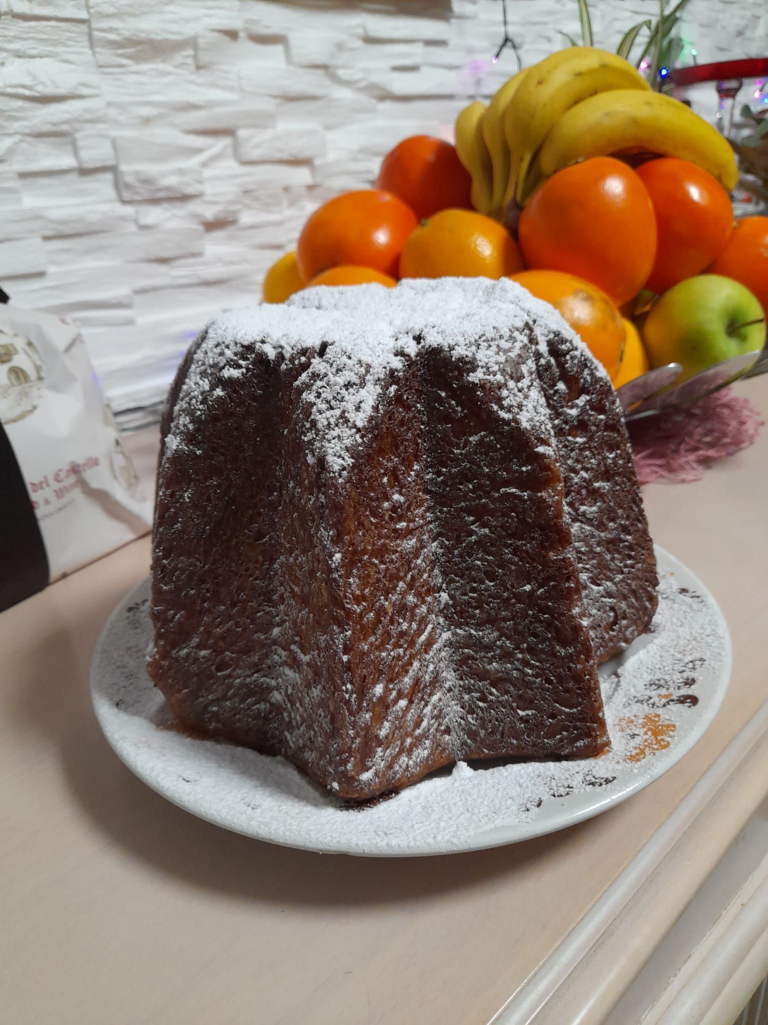 un gâteau au chocolat est sur une assiette blanche à côté d' un bol de fruits .