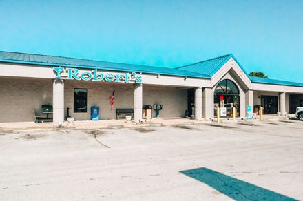Exterior of Robert's store in a strip mall, with a blue roof, and a blue sign.