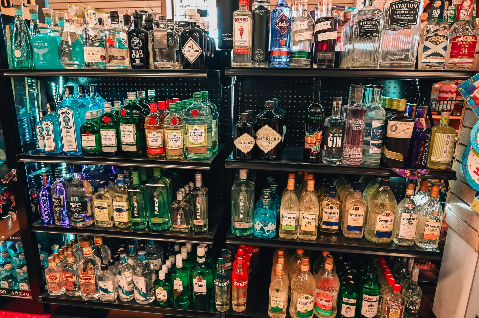Shelves stocked with various liquor bottles in a store, including gin and other clear spirits.