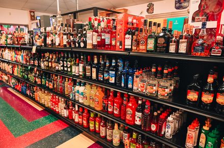 Shelves stocked with various liquor bottles inside a store.