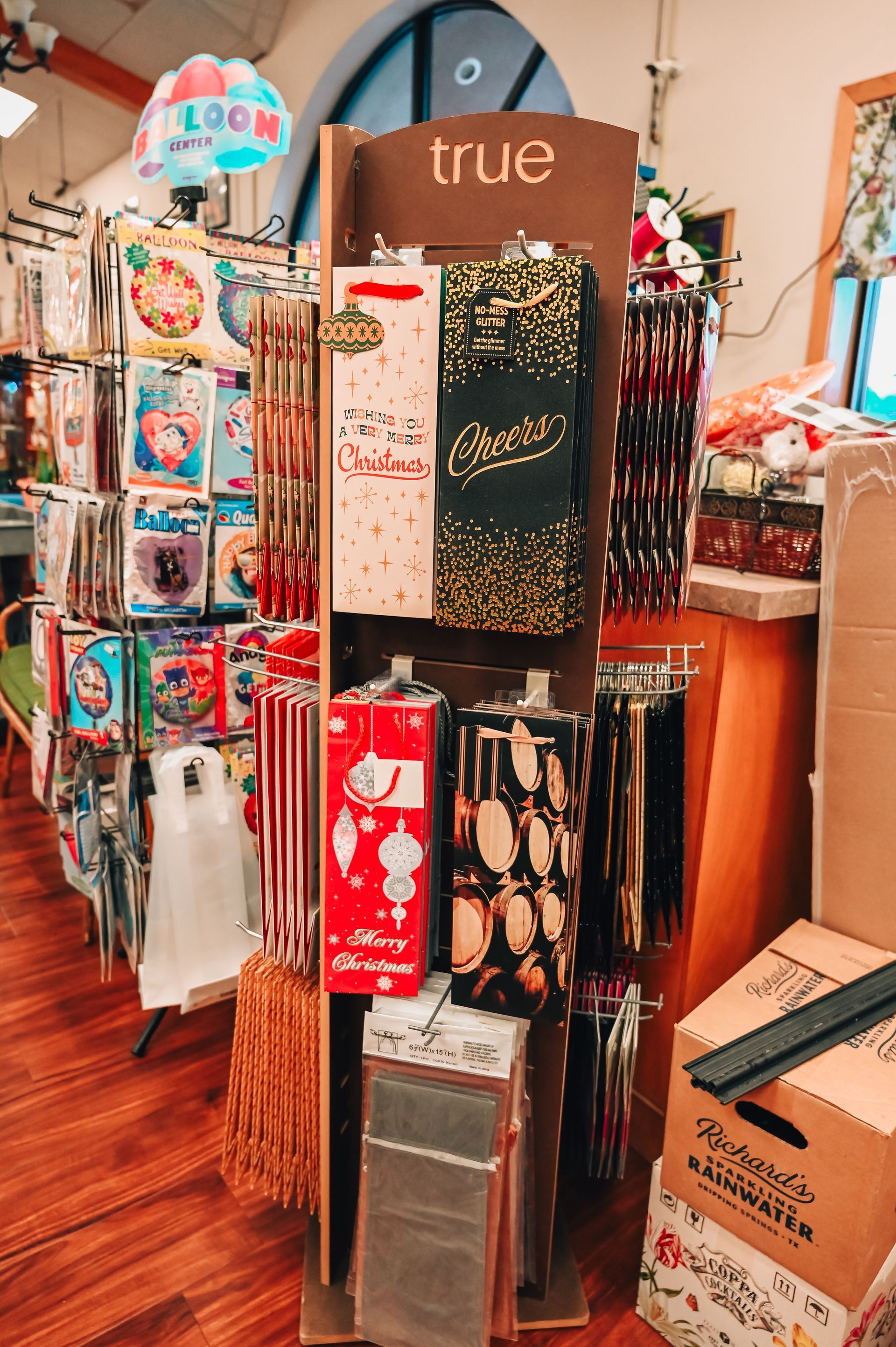 Display of gift bags and ornaments in a shop, with balloons visible.