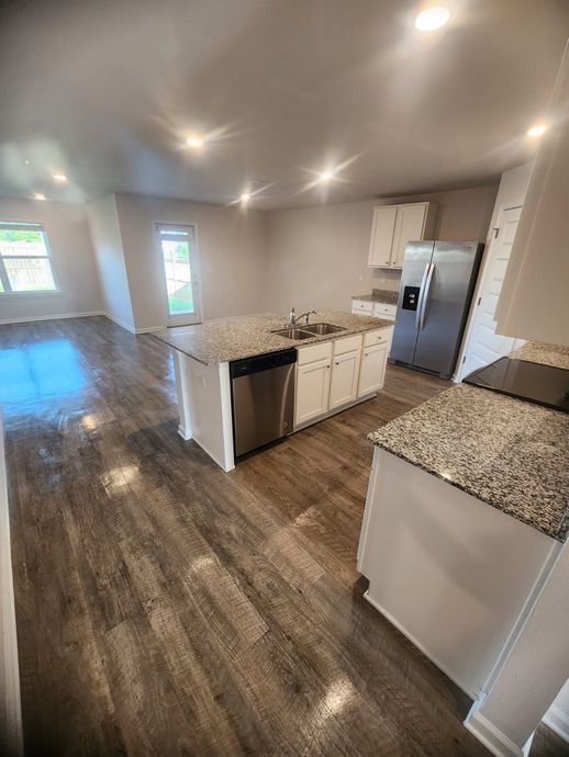 A kitchen with stainless steel appliances and granite counter tops.