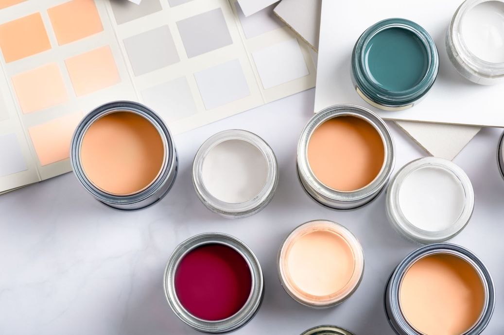 A bunch of cans of paint are sitting on a table.