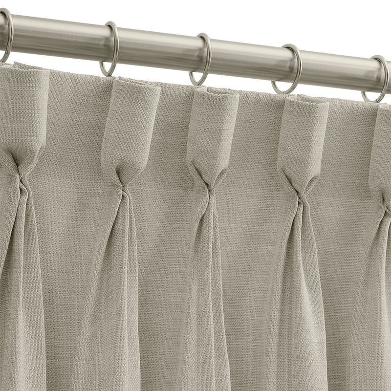 Green velvet curtains frame an open doorway. A window with a patterned shade, and a cream armchair complete the scene.