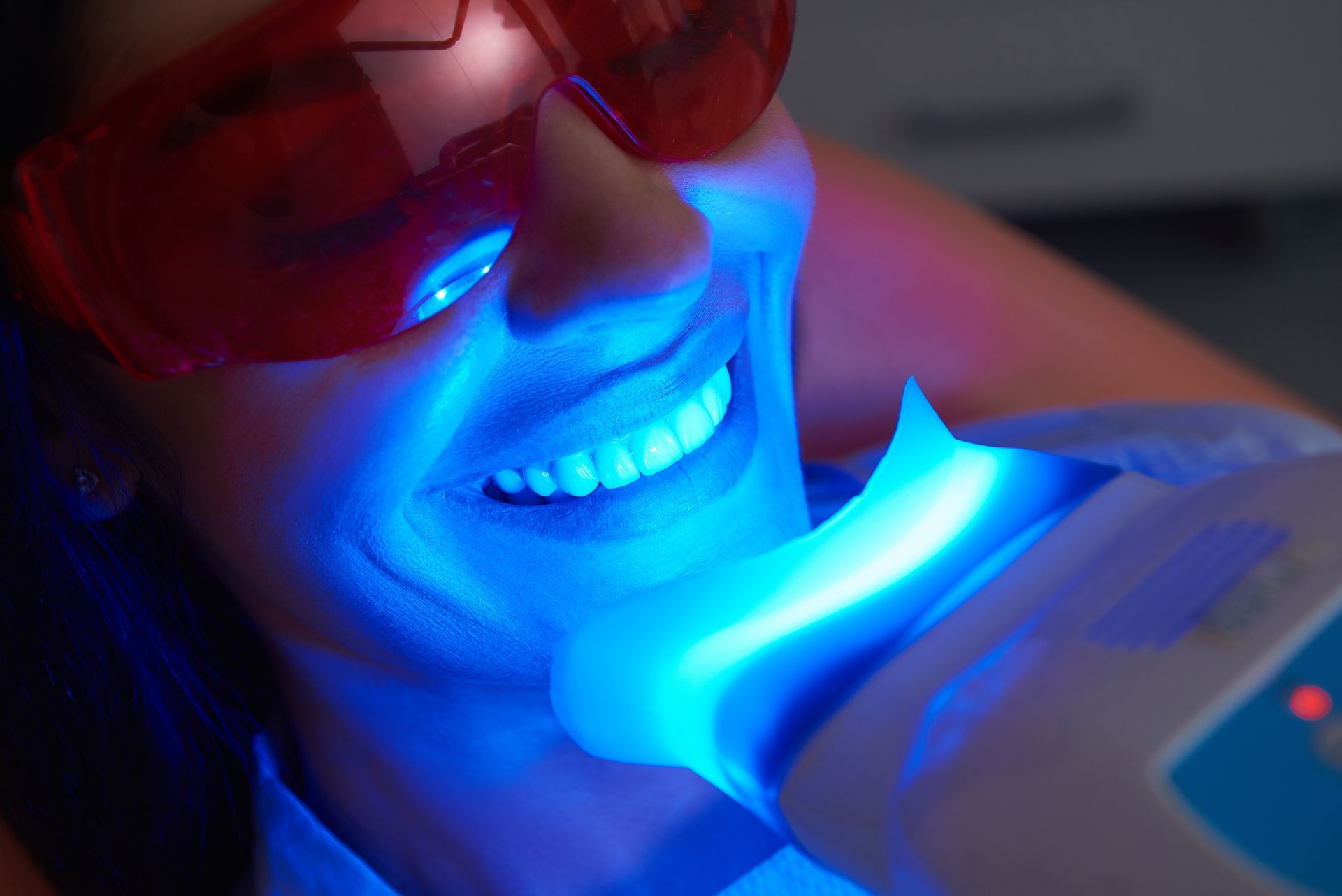Close-up of happy lady doing dental whitening treatment in dental clinic. Close-up of happy lady doing dental whitening treatment in dental clinic.
