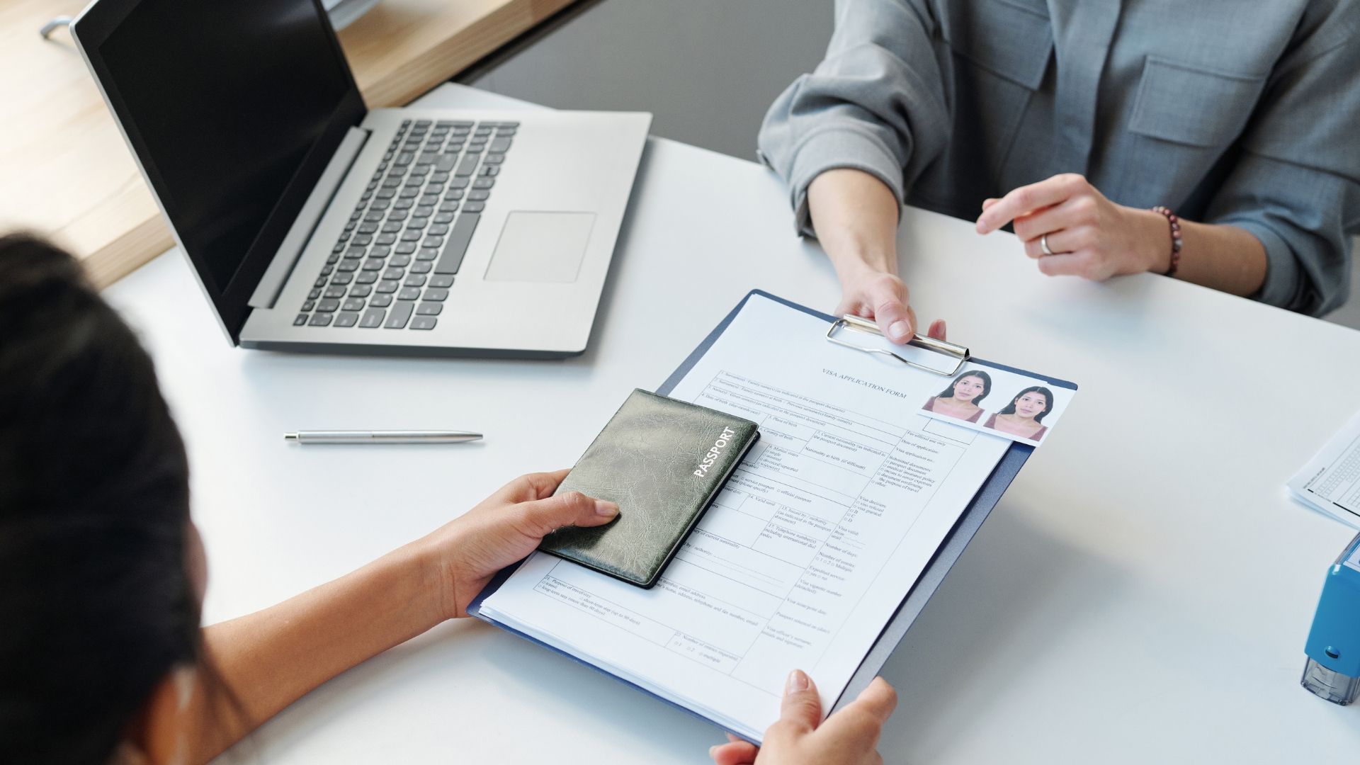 A woman is giving a resume to another woman at a table.