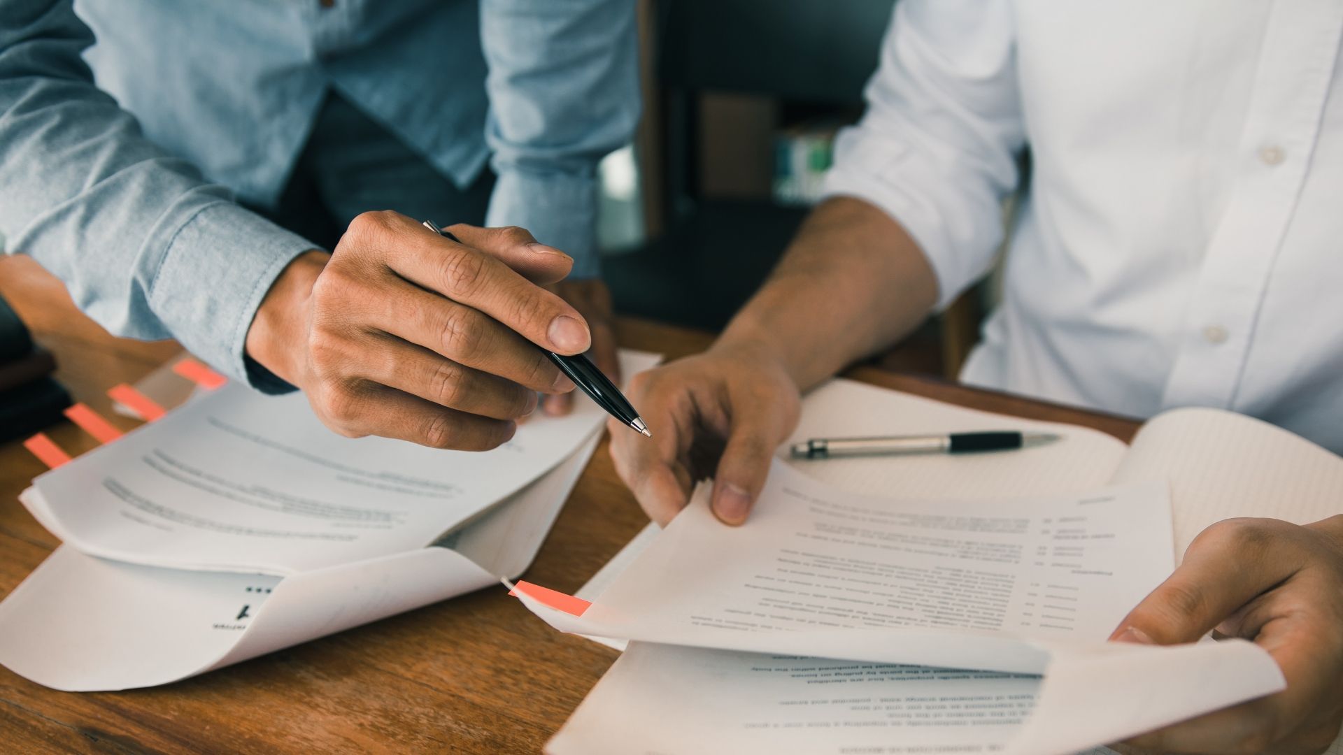 Two people are sitting at a table looking at papers.