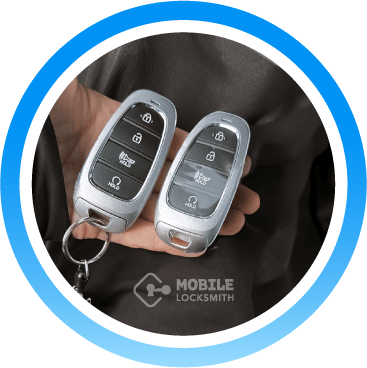 Close-Up Of A Car Locksmith Technician Holding Two Silver Key Fobs.