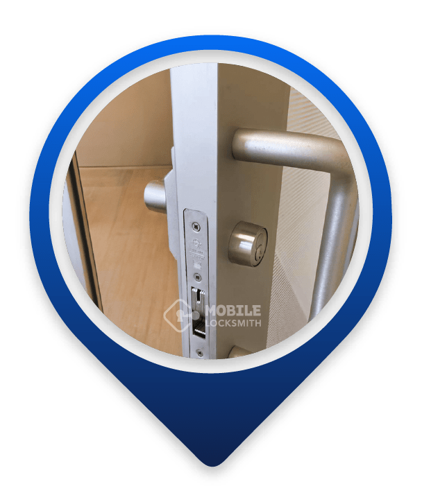 Close-Up Of Partially Open Metal Door with Cylindrical Lock And Large Horizontal Handle.